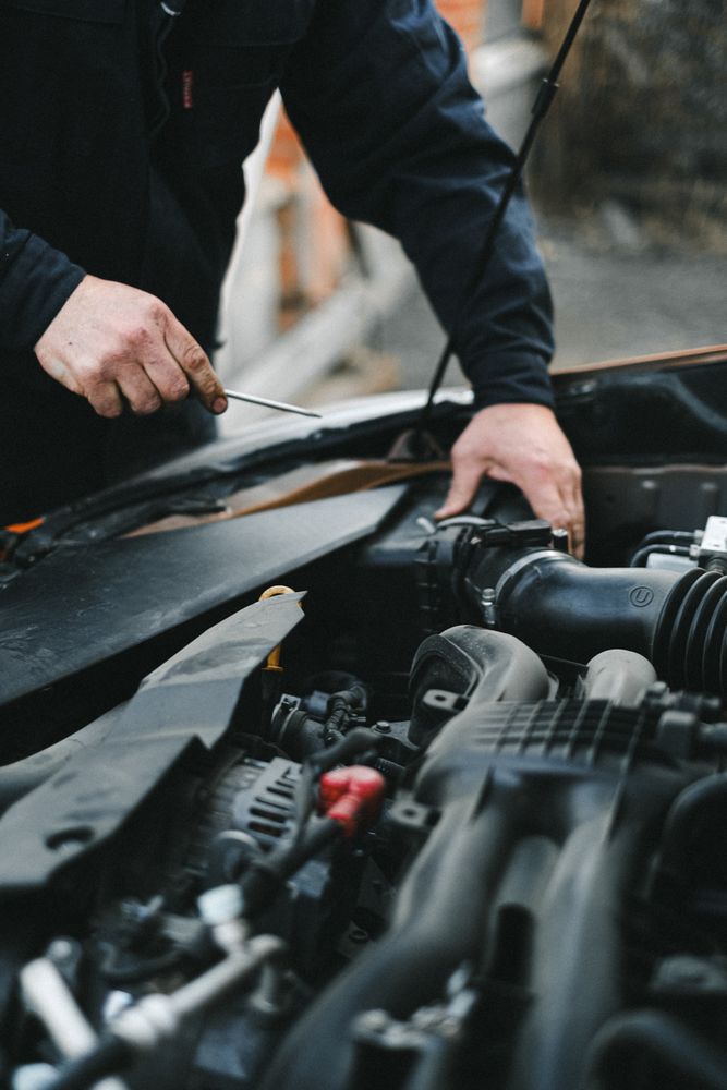 Ilustrační fotografie mechanika při opravě motoru
